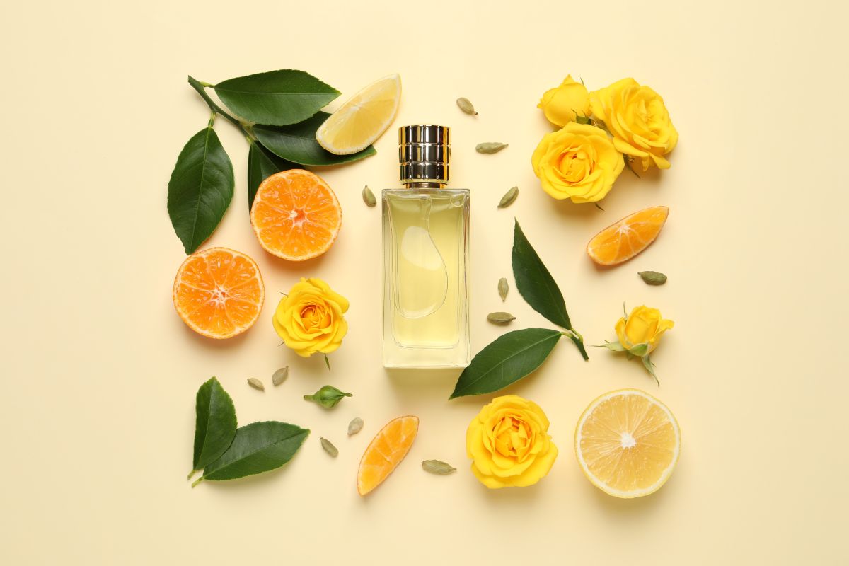 citrus fruits laid out next to perfume bottle